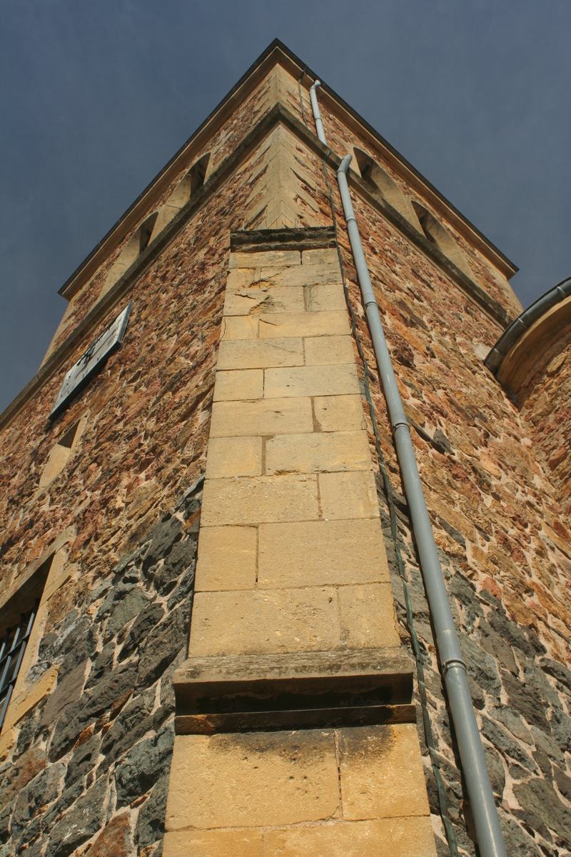 Contrefort et corniche de pierre de l'église Saint-Genest de Vendranges, vus en contre-plongée.