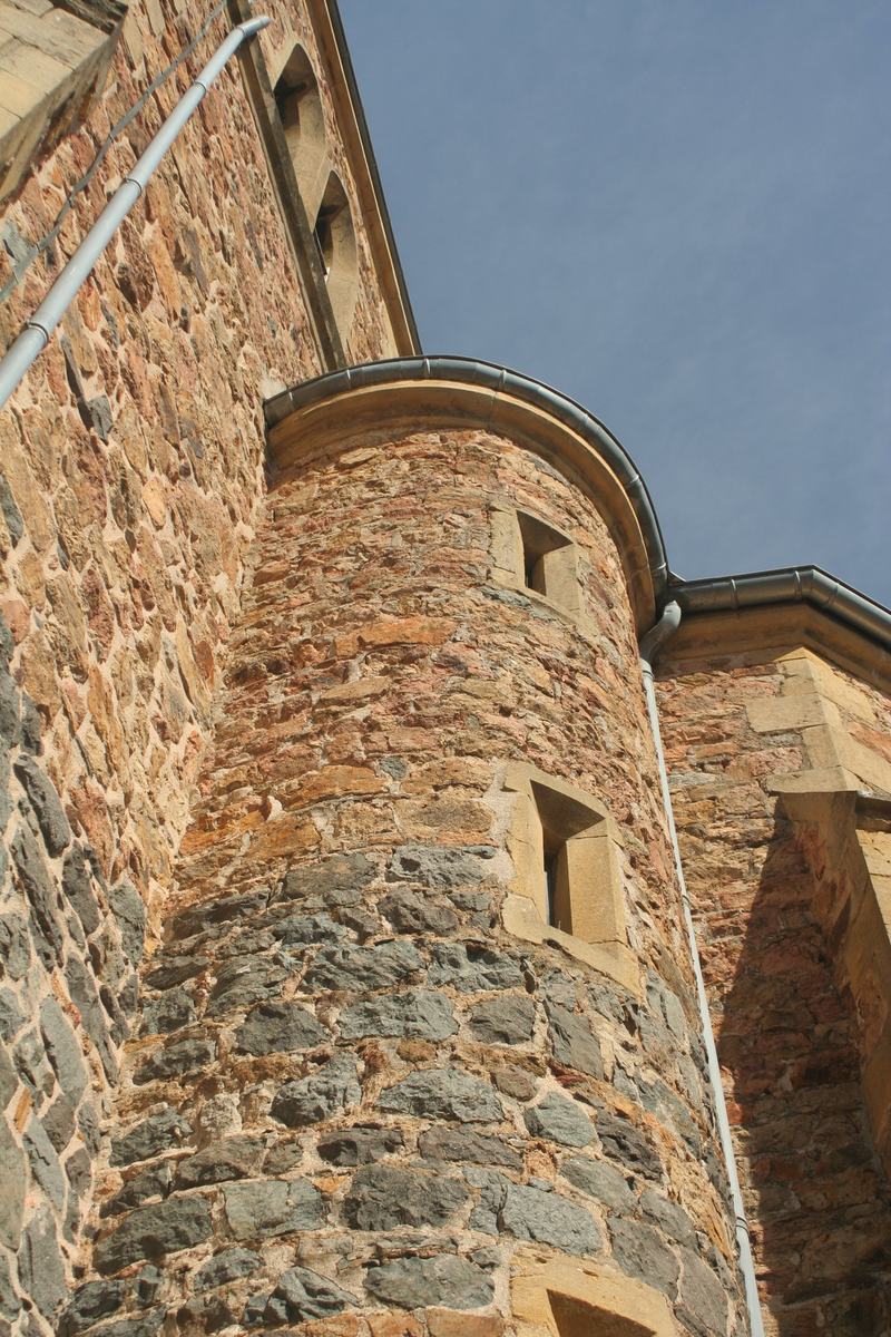 Tour ronde fortifiée de l'église Saint-Genest de Vendranges, avec ses meurtrières et son appareillage de pierre du pays.