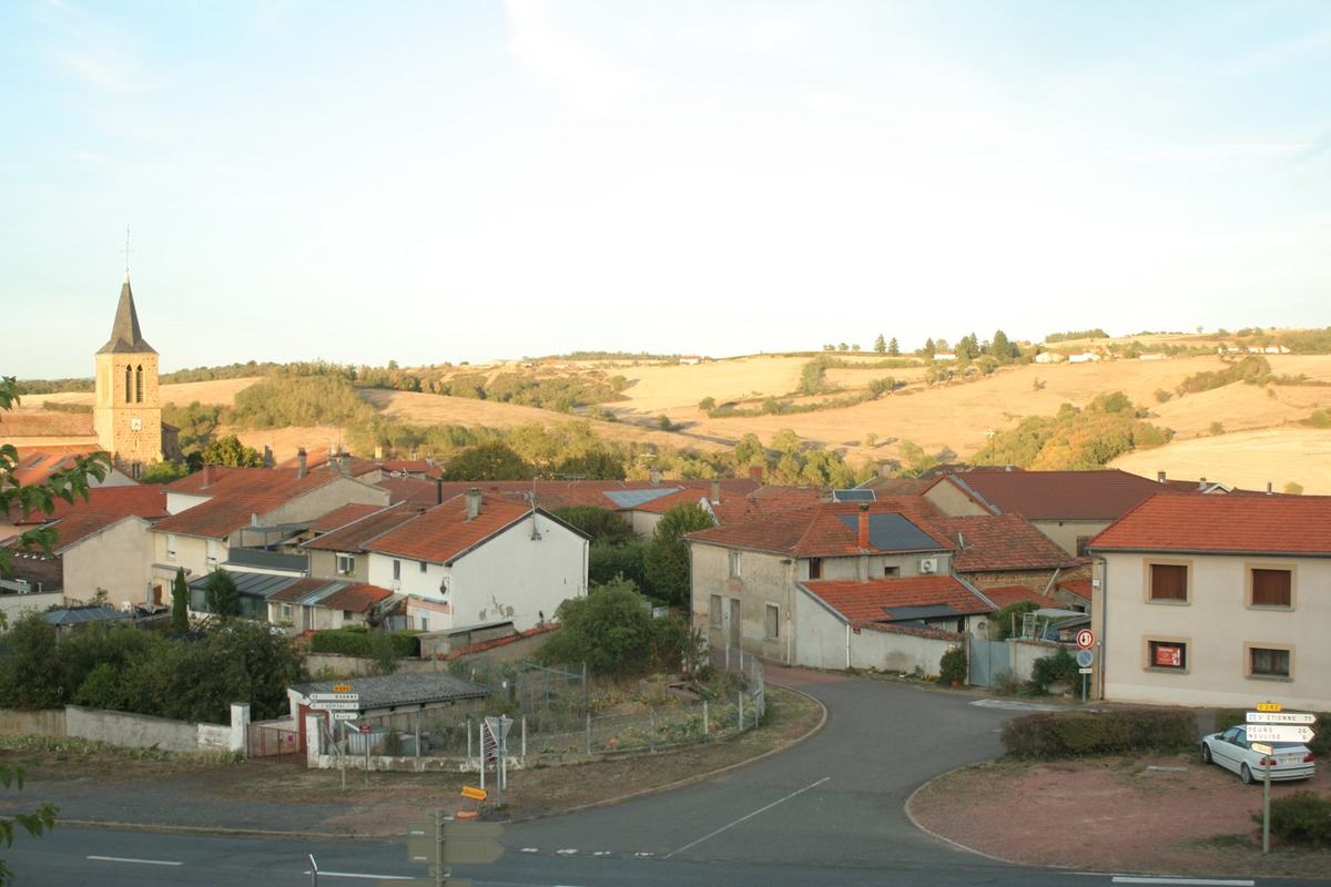 Vue générale de Vendranges depuis les hauteurs, avec le clocher de l'église Saint-Genest et les collines du Roannais.