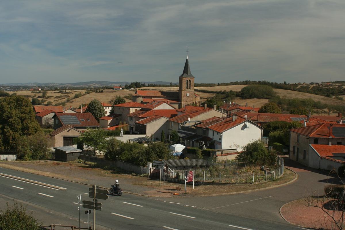 Entrée du village de Vendranges depuis la route, avec le clocher de l'église en arrière-plan et un carrefour giratoire.
